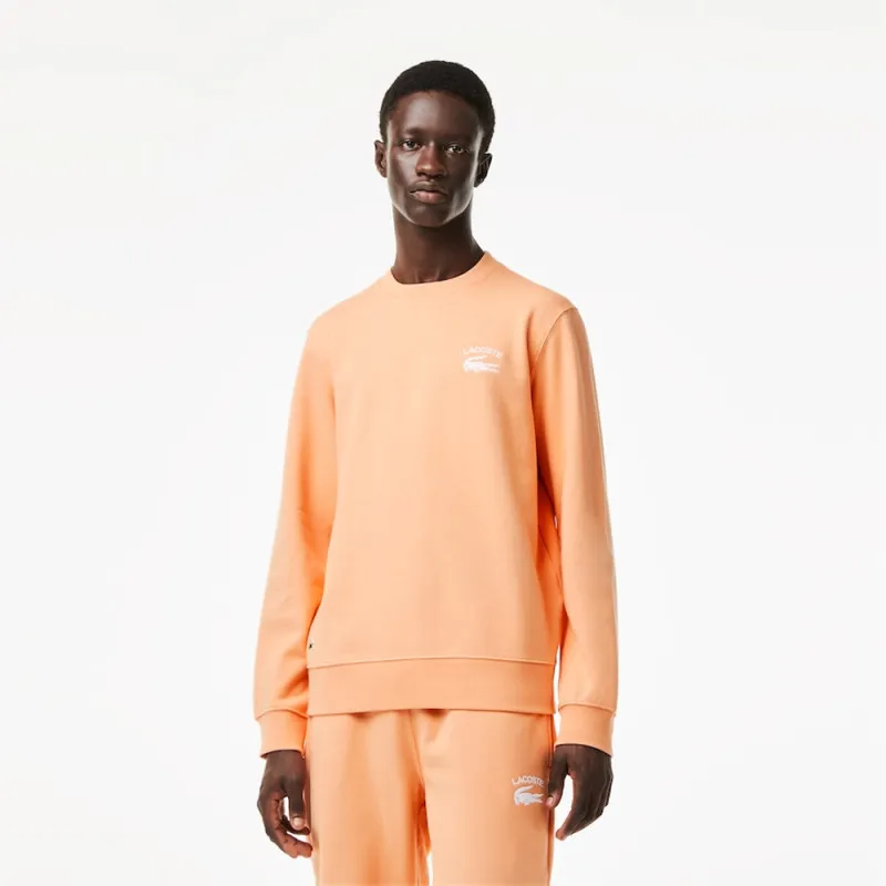 SWEATSHIRT ORANGE COL ROND AVEC INSCRIPTION DANS LE DOS LACOSTE